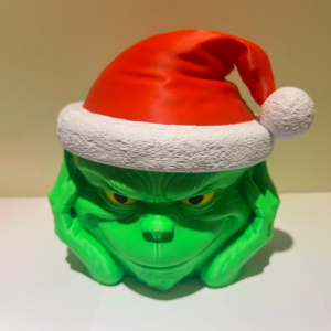 Kalėdinė saldaininė su žaismingu personažo veidu ir Kalėdų kepure